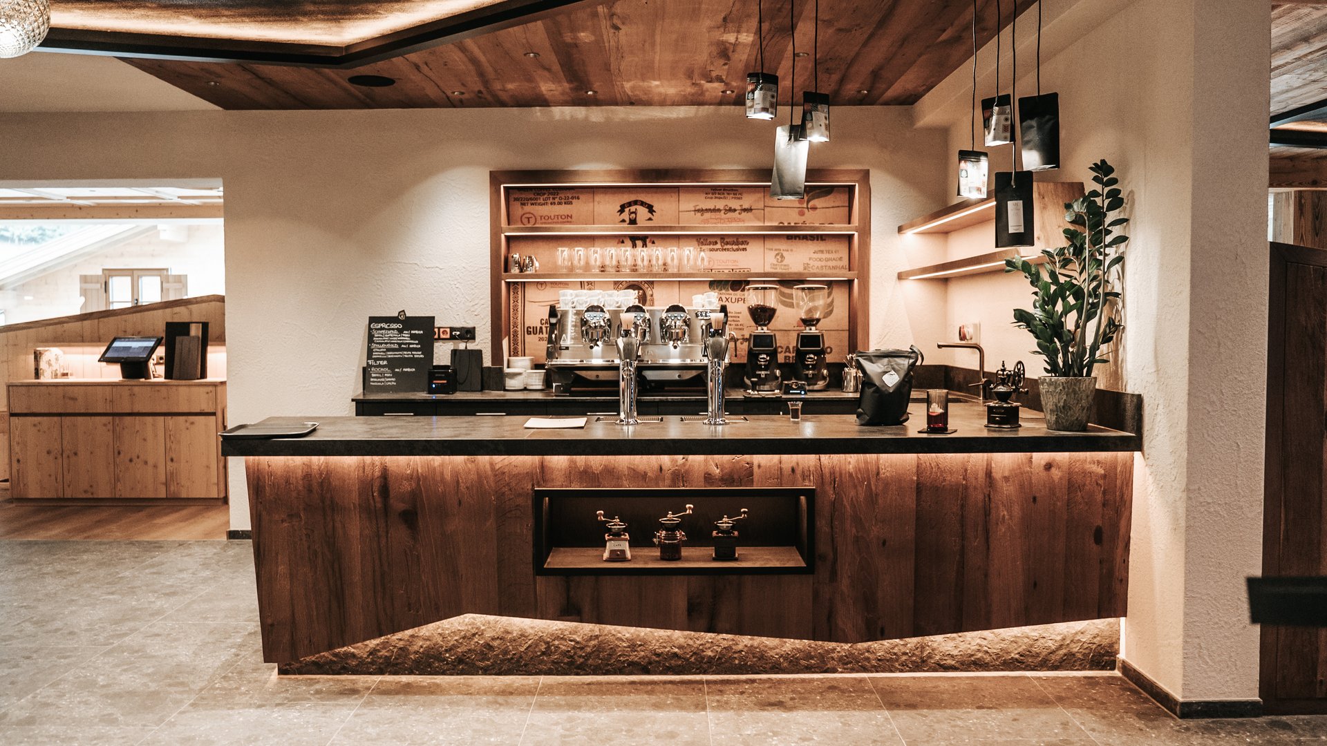 Kulinarik Moderne Kaffeebar mit Holztheke und Espressomaschinen in warmem Ambiente