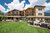 Modernes Hotel mit Terrasse und Garten vor Bergkulisse