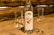Flasche Apfelbrand mit zwei leeren Schnapsgläsern auf Holztisch