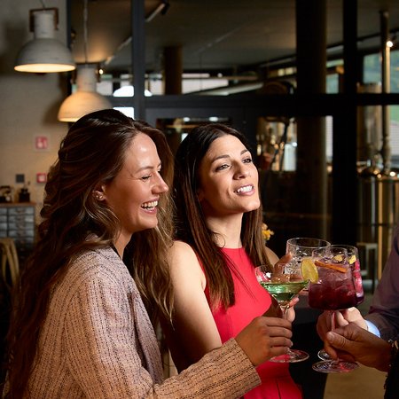 Settimane del Gusto Donne brindano con cocktail colorati in un bar moderno
