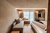 Die Bildergalerie Gemütliches Hotelzimmer mit Sofa, Bett und großem Fenster mit Vorhängen