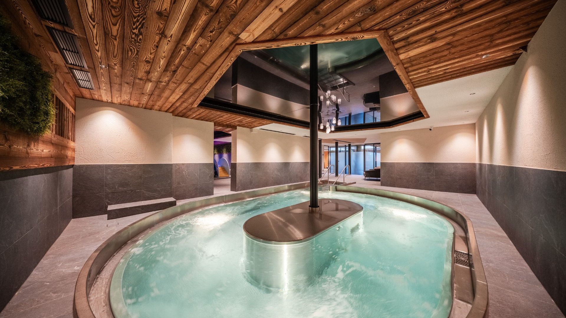 Gassenbadl: l’area wellness per famiglie Piscina interna con acqua gorgogliante e soffitto in legno