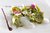 Grüne Tortellini mit Schaum, Gemüse und Blüten kunstvoll auf weißem Teller angerichtet
