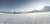 Zwei Skifahrer auf frisch präparierter Piste bei sonnigem Winterwetter in den Bergen