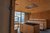 Galleria immagini Sauna in legno con panche, stufa e vista sulle montagne attraverso la vetrata