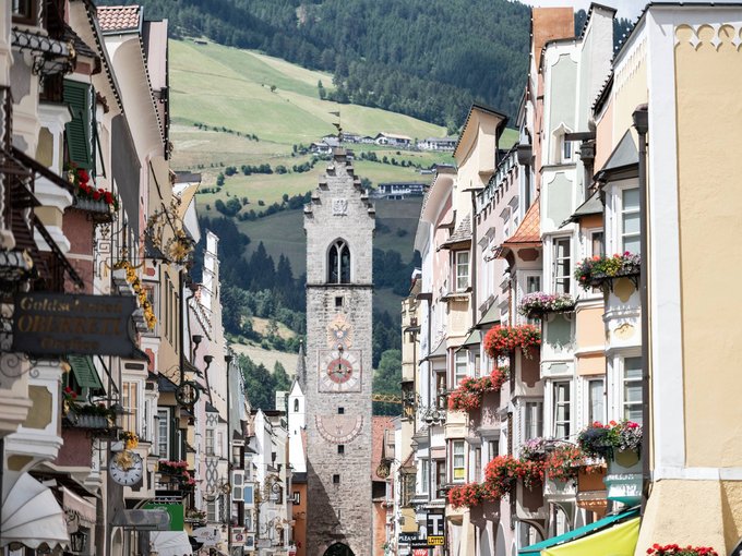 Vipiteno srotola il tappeto rosso Case colorate e torre dell'orologio in una pittoresca città alpina