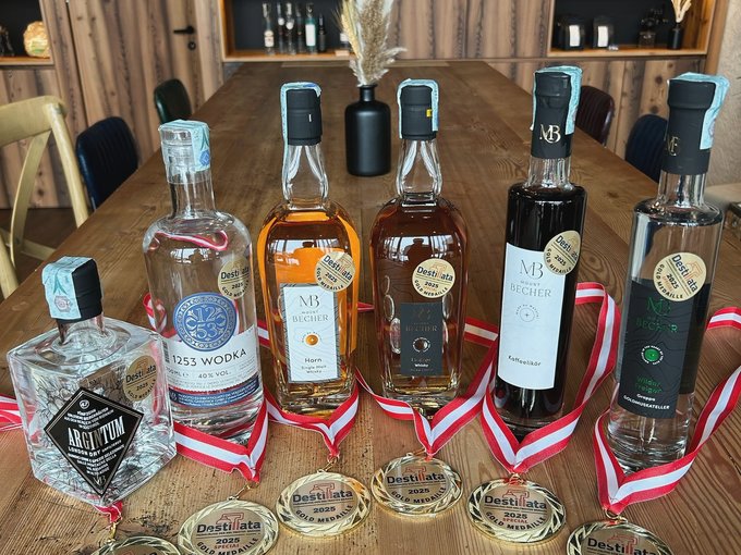 Una delle migliori distillerie di grappa Diverse bottiglie di liquori premiati con medaglie d'oro su tavolo di legno