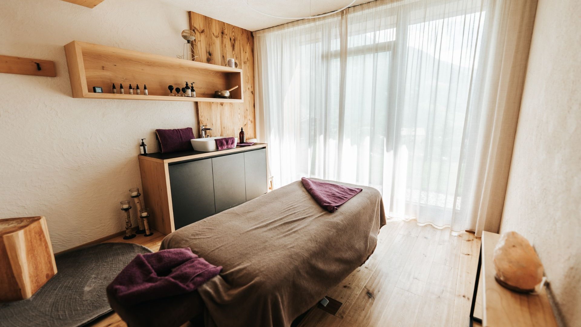The best spot in the Ridnauntal valley Bright treatment room with massage table, wooden shelves and large windows