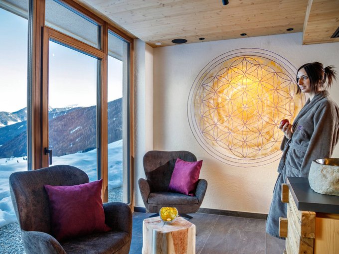 Die Wasserwelt Frau im Bademantel in gemütlichem Raum mit Bergblick auf Schnee