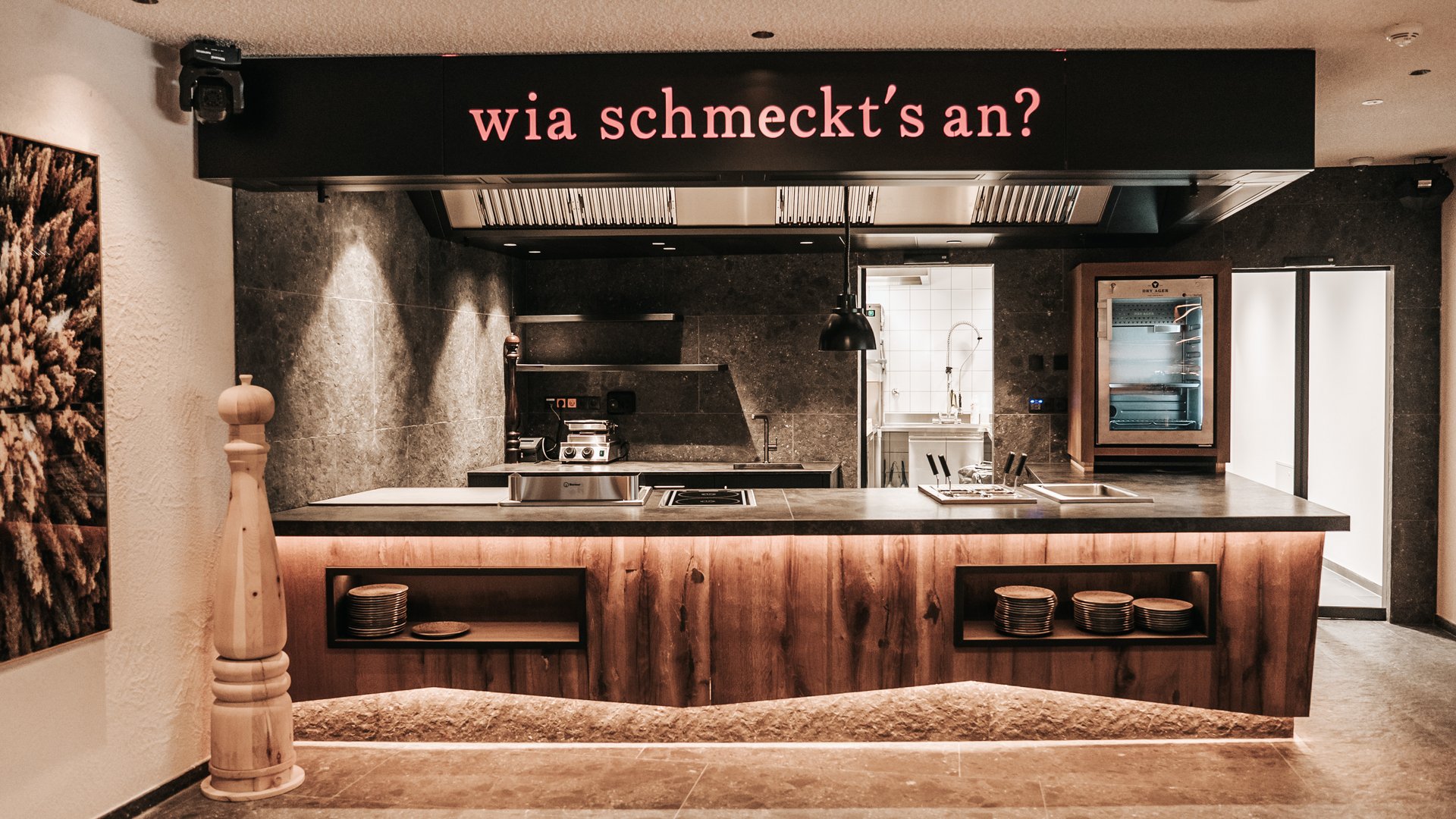 The Gassenhof gourmet cuisine Modern restaurant kitchen with wooden front and sign wia schmeckt's an