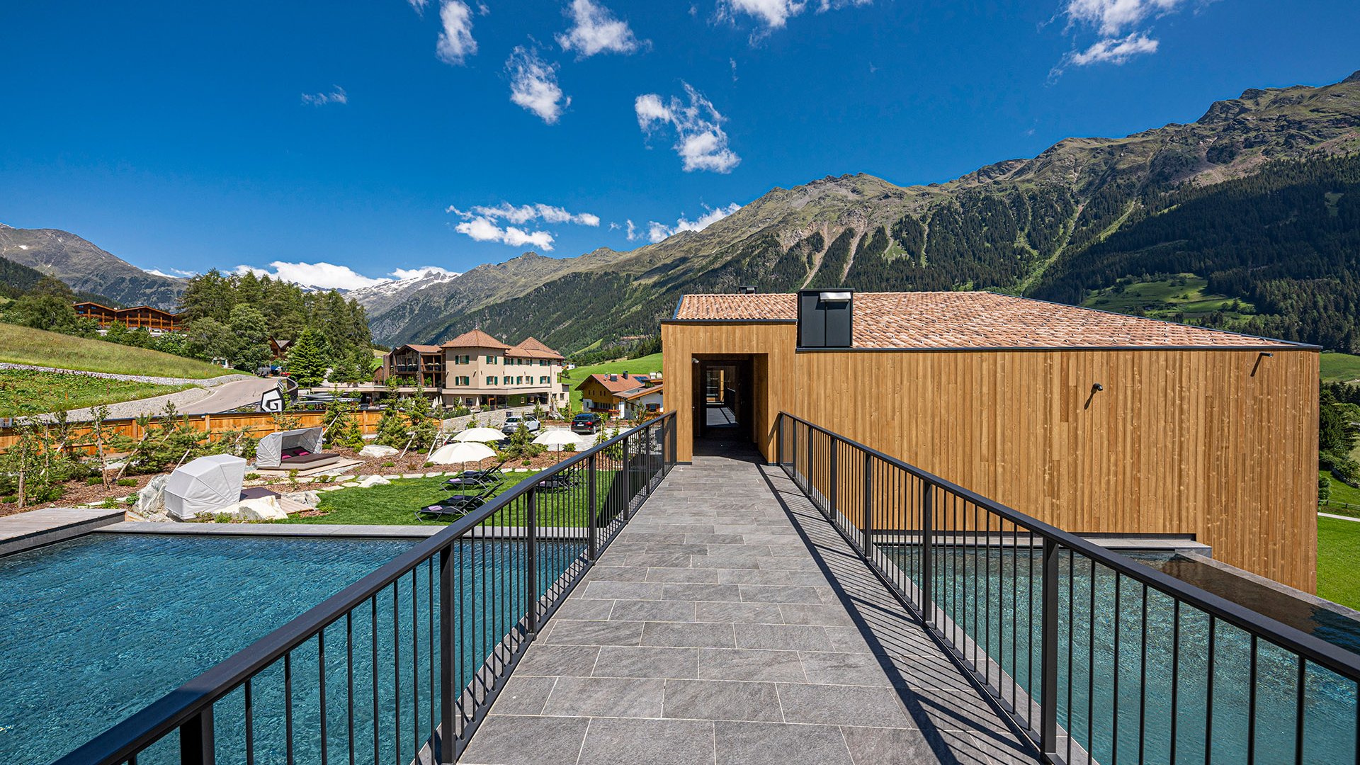 The best spot in the Ridnauntal valley Bridge over pool at hotel with mountain view on sunny day