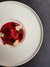 Feines rotes Dessert mit Dekoration auf weißem Teller