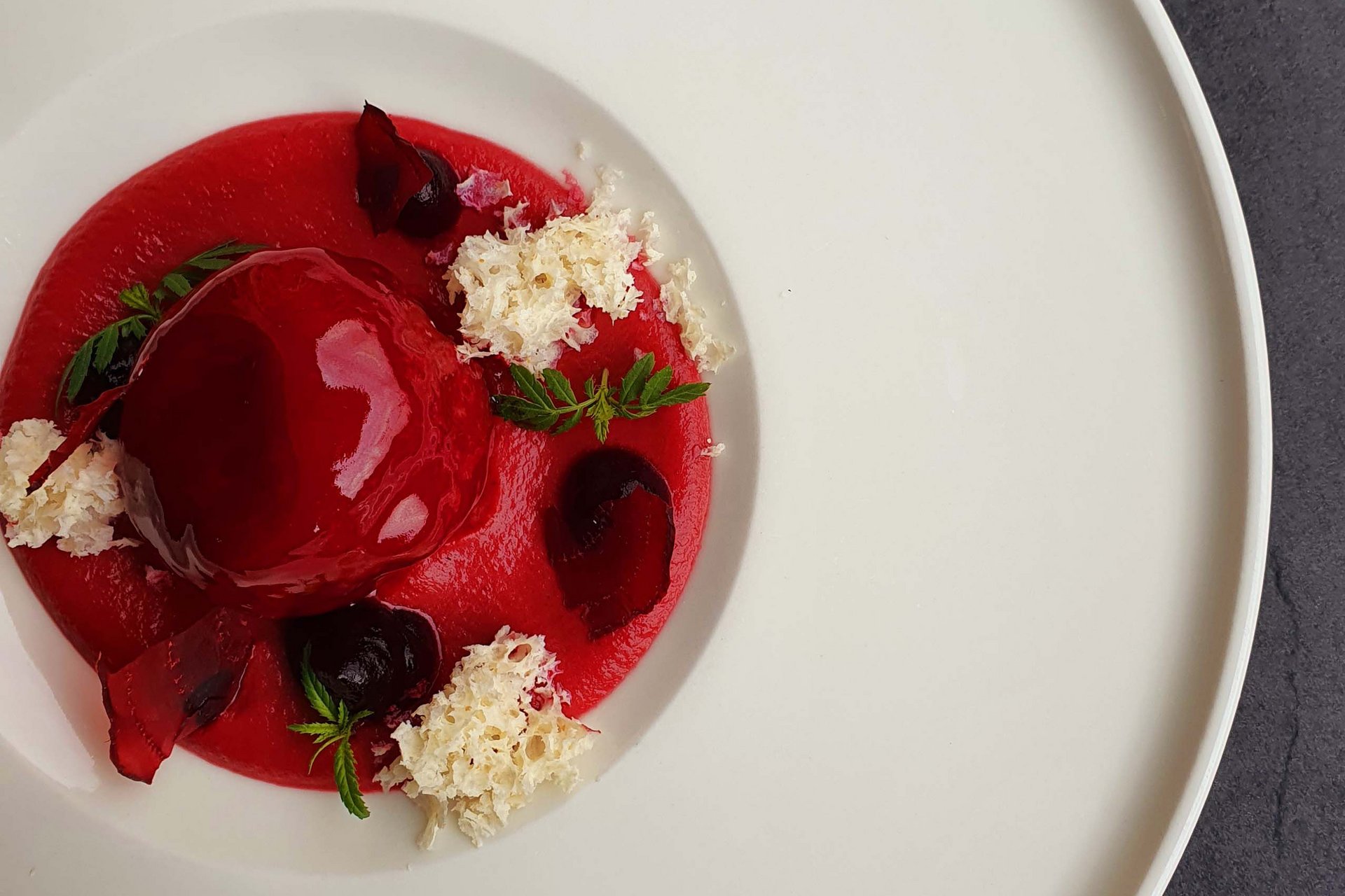 Urlaub anfragen Feines rotes Dessert mit Dekoration auf weißem Teller