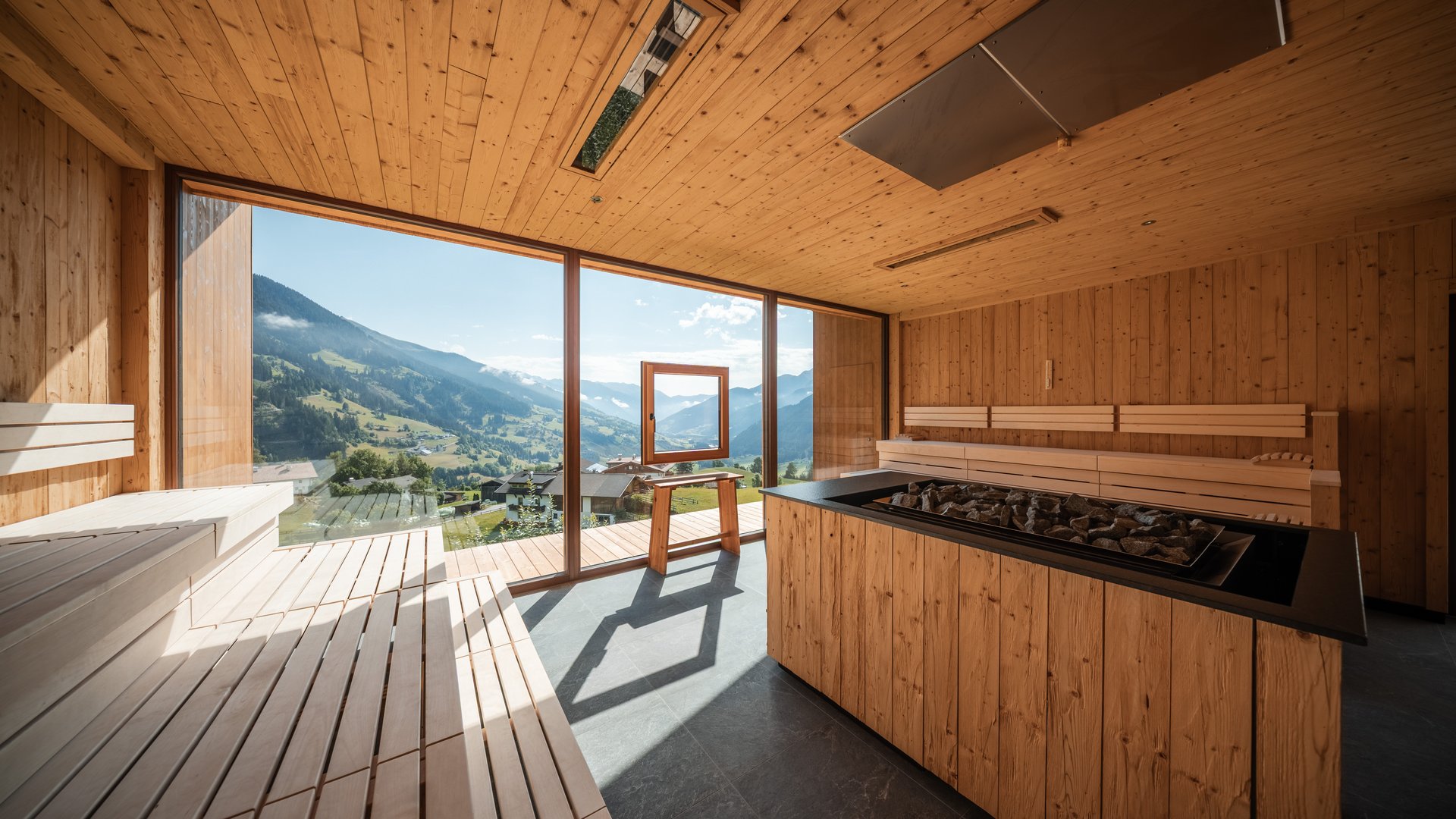 L’area wellness riservata agli adulti Sauna in legno con vetrate panoramiche e vista sulle montagne alpine