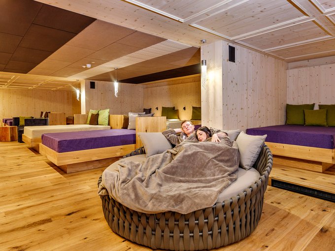 Wanderhotel Coppia rilassata su divano rotondo con coperta in stanza relax di benessere
