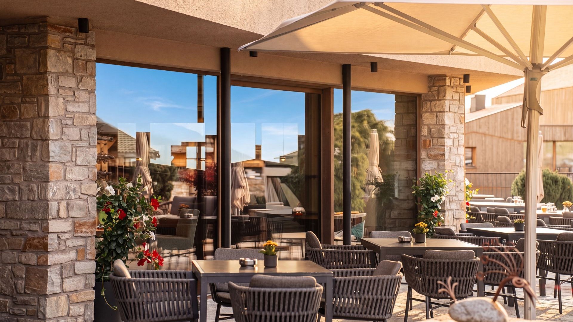 Sapori Terrazza coperta del ristorante con tavoli, sedie in vimini e fiori