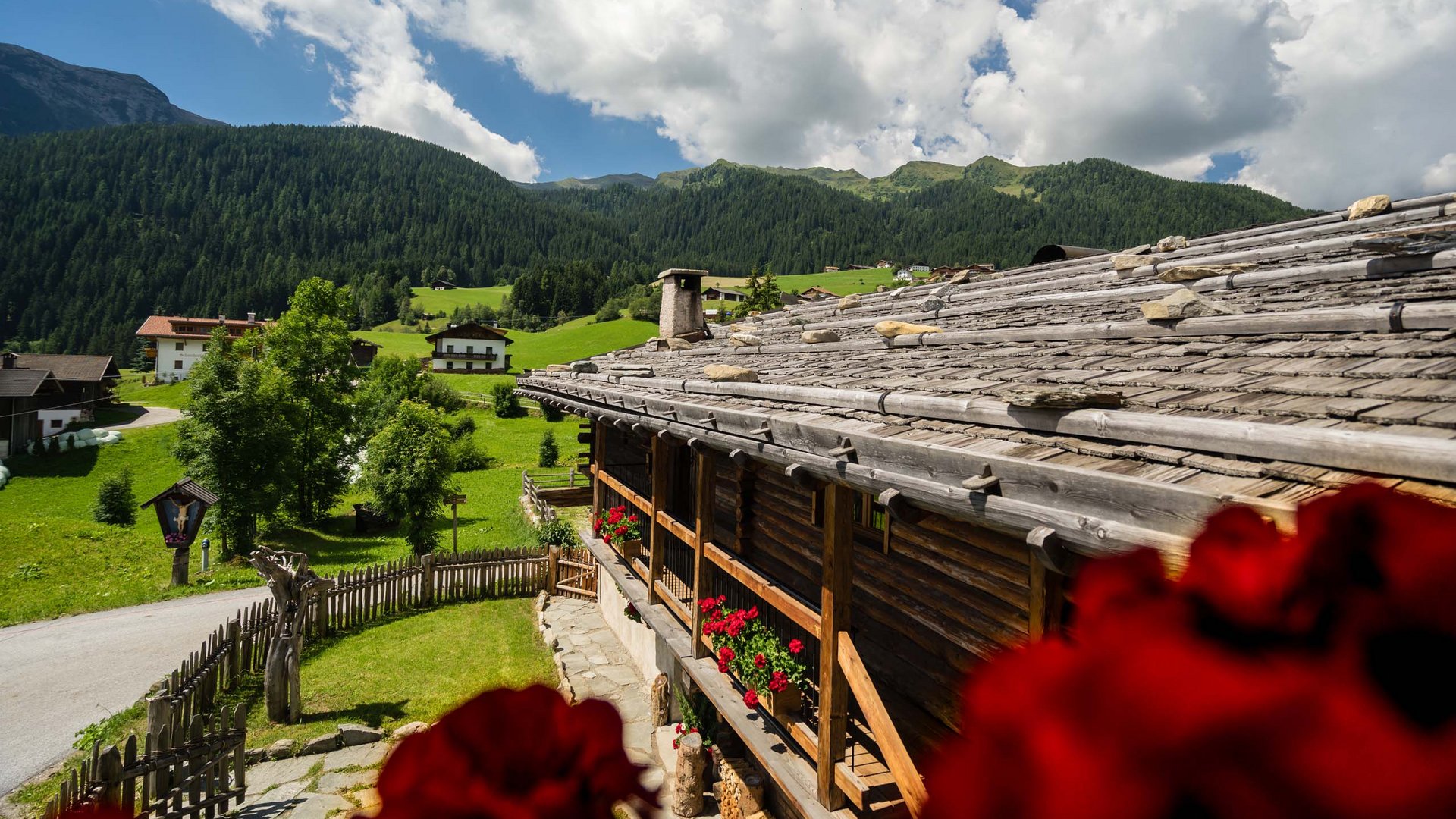 The historical Chalet Gratznhäusl Old mountain hut with green alpine landscape and blue sky with clouds