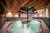 Galleria immagini Piscina interna con acqua gorgogliante, soffitto in legno e isola centrale