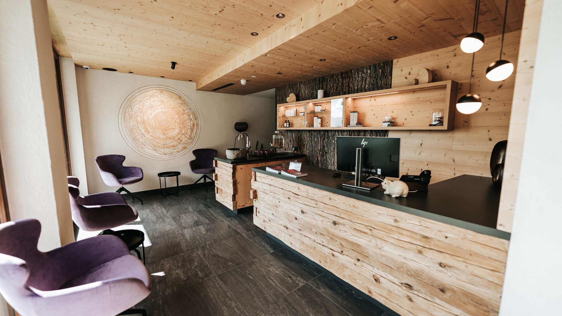 Logen Spa Reception di hotel moderna con bancone in legno e poltrone viola