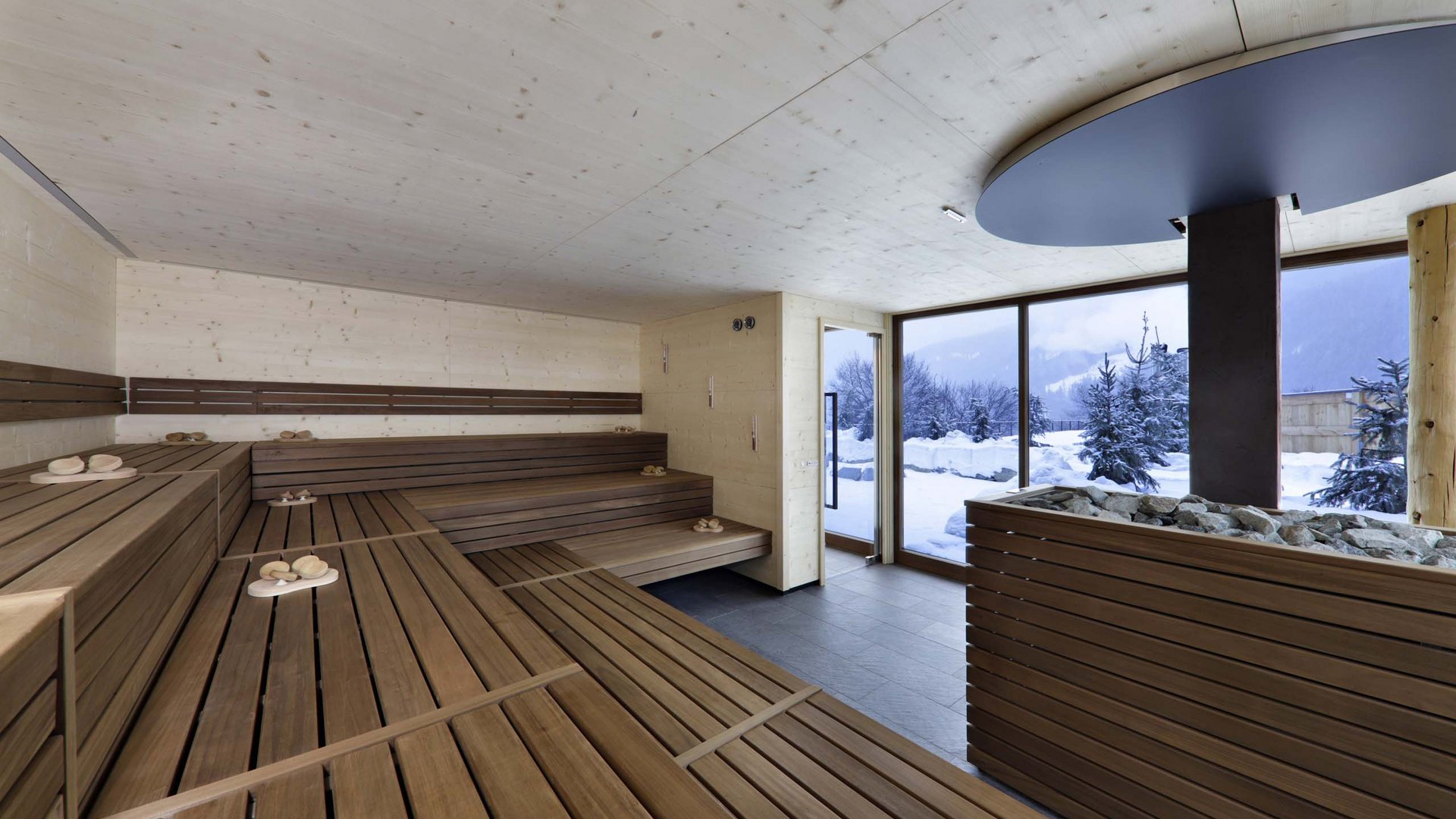 Hotel a Racines con centro benessere Sauna in legno moderna con grandi finestre e vista sulla neve