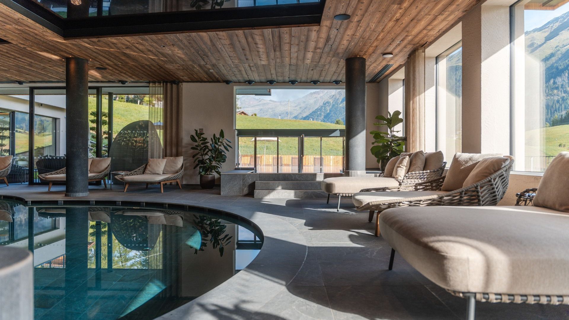 Home Erlebnisort Gassenhof Bright indoor pool with loungers and mountain views through large windows