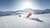 Zwei Skifahrer fahren einen frisch präparierten Hang bei sonnigem Wetter hinunter