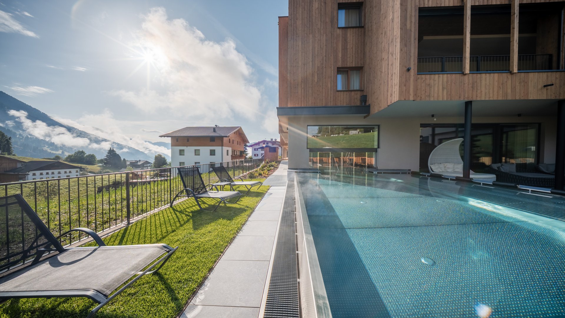 Gassenbadl: l’area wellness per famiglie Piscina esterna riscaldata con lettini e vista sulle montagne presso un hotel