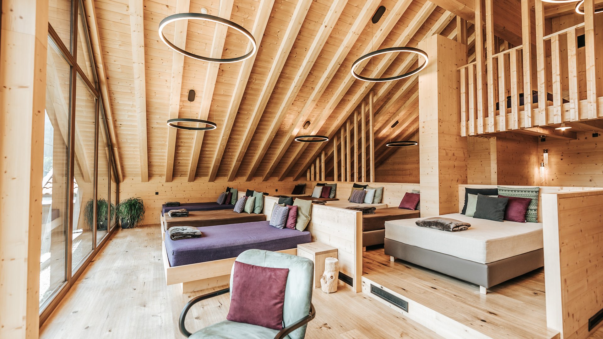 L’area wellness riservata agli adulti Ampio ambiente in legno con diversi letti, area soggiorno e grandi finestre