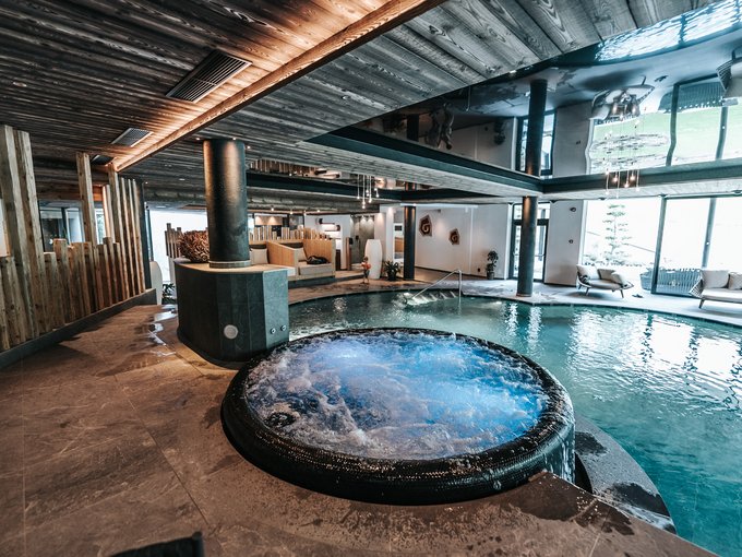 Gassenbadl: Familienwasserwelt Innenpool mit Whirlpool und moderner Holzdecke in einem Wellnessbereich