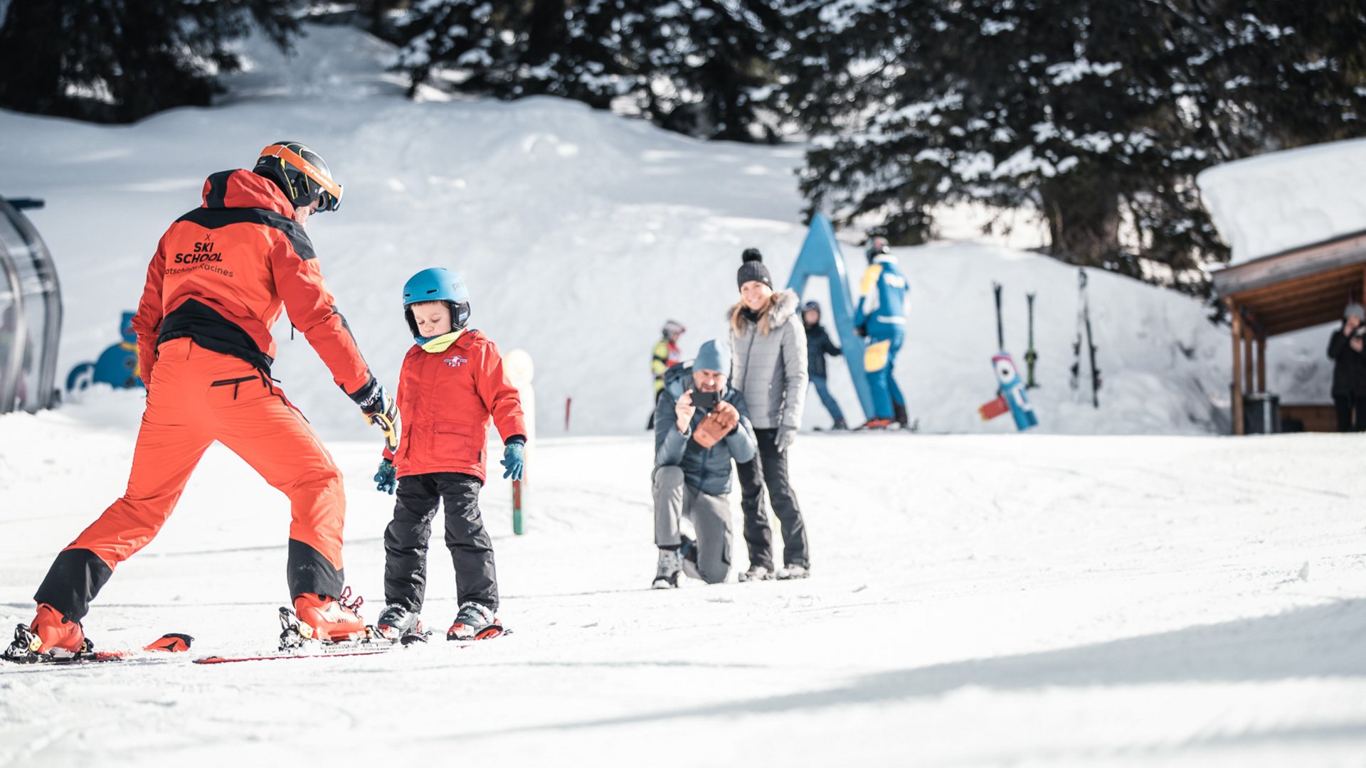 Familienurlaub im Gassenhof Skilehrer und Kind beim Skifahren im verschneiten Skigebiet