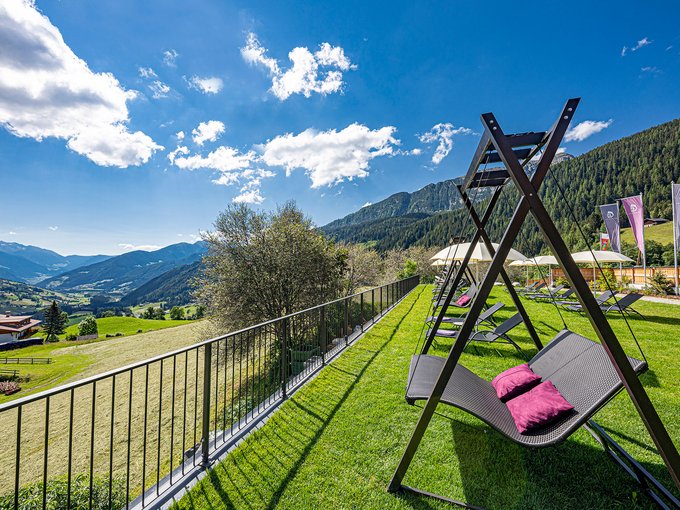 Die Wasserwelt Schaukelliegen mit Blick auf grüne Berge und Tal unter blauem Himmel