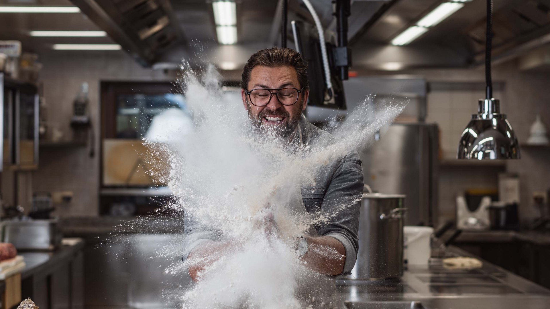 The Gassenhof gourmet cuisine Baker throwing flour in a professional kitchen
