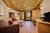 Gemütliches Wohnzimmer mit Holzmöbeln, Sofa, TV und Balkon mit Bergblick