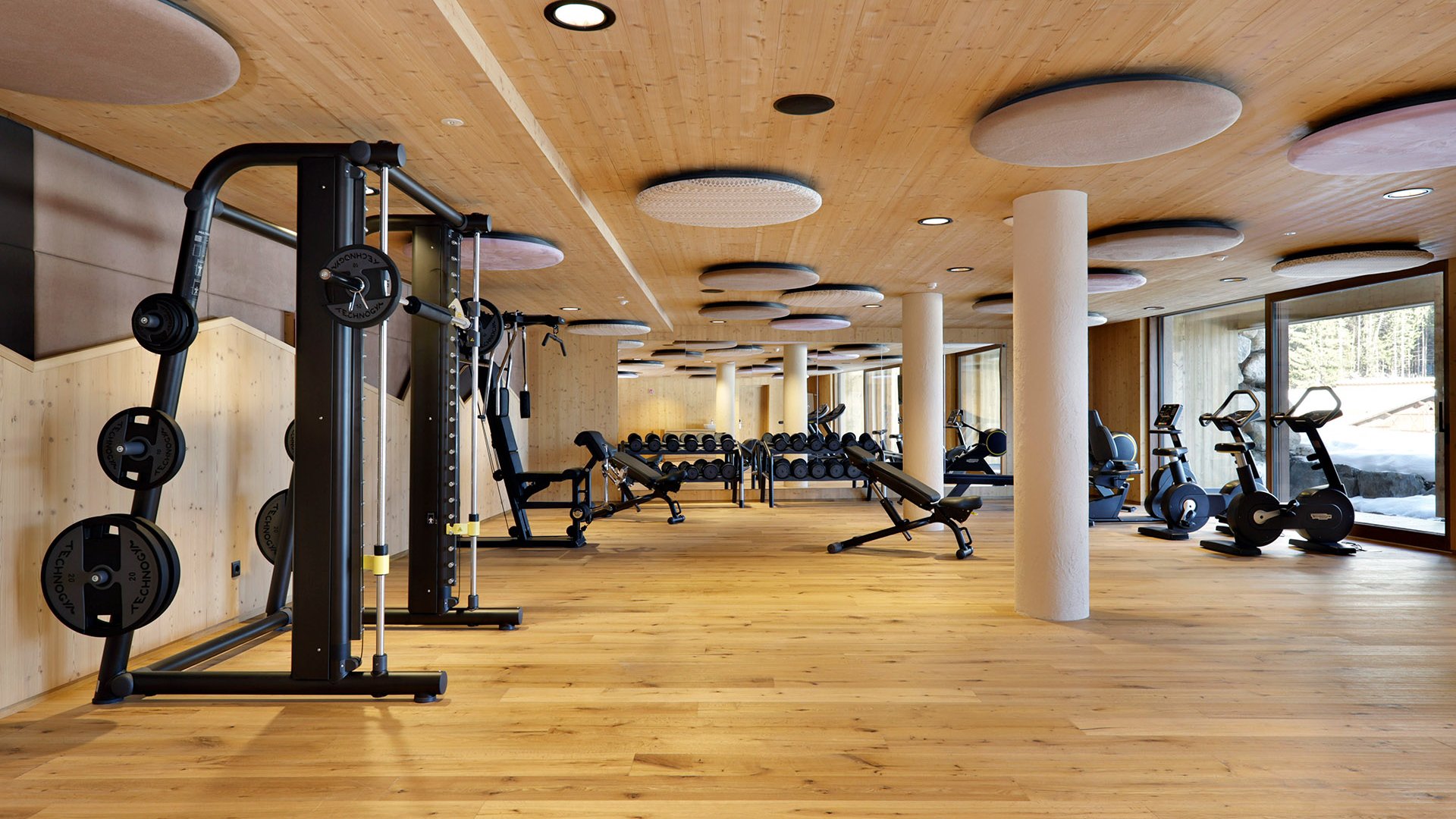 Fitness und Yoga Moderner Fitnessraum mit Kraftgeräten und Blick auf verschneite Landschaft