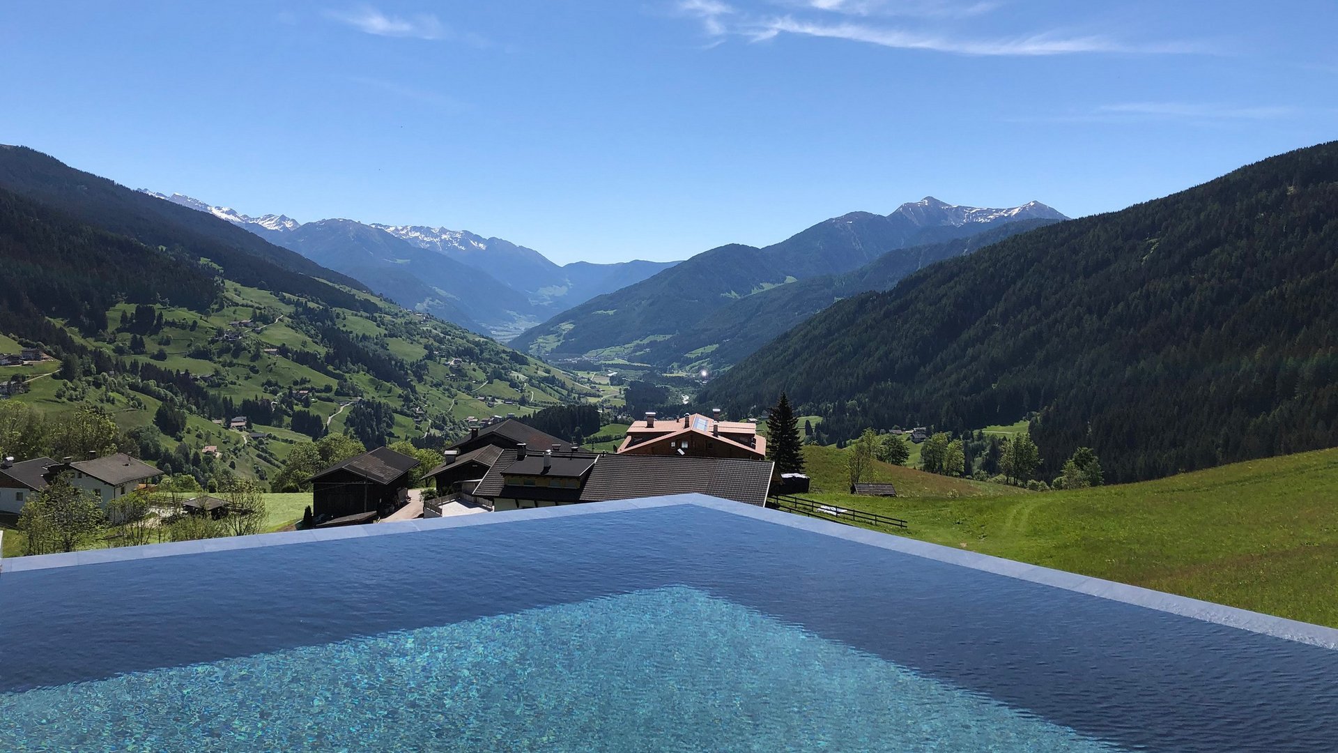 The best spot in the Ridnauntal valley Infinity pool overlooking green mountains and snowy peaks