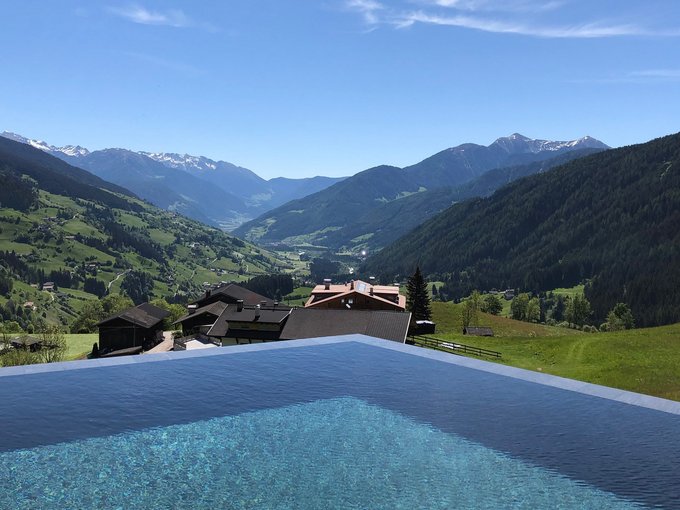 La Val Ridanna Piscina a sfioro con vista su montagne verdi e cime innevate