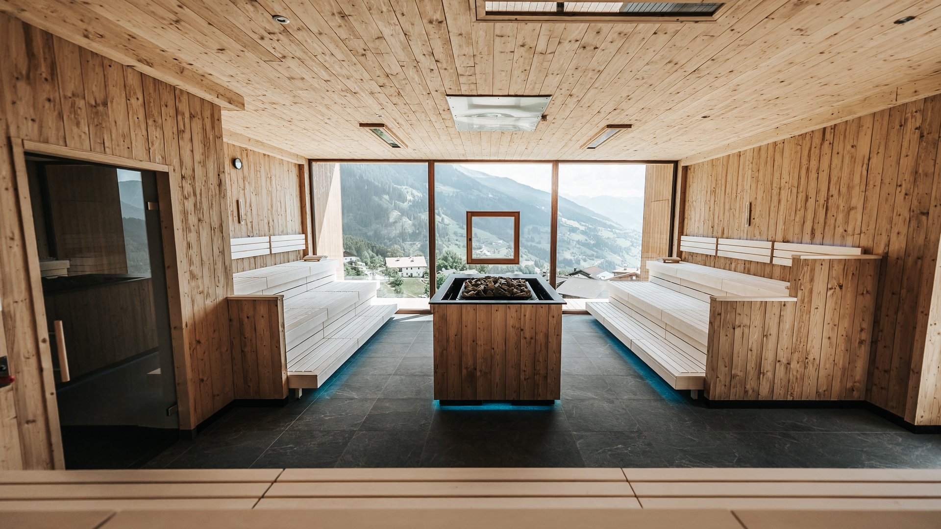 Das Wellnessbereich für Erwachsene Moderner Holzsauna-Raum mit großen Fenstern und Bergblick