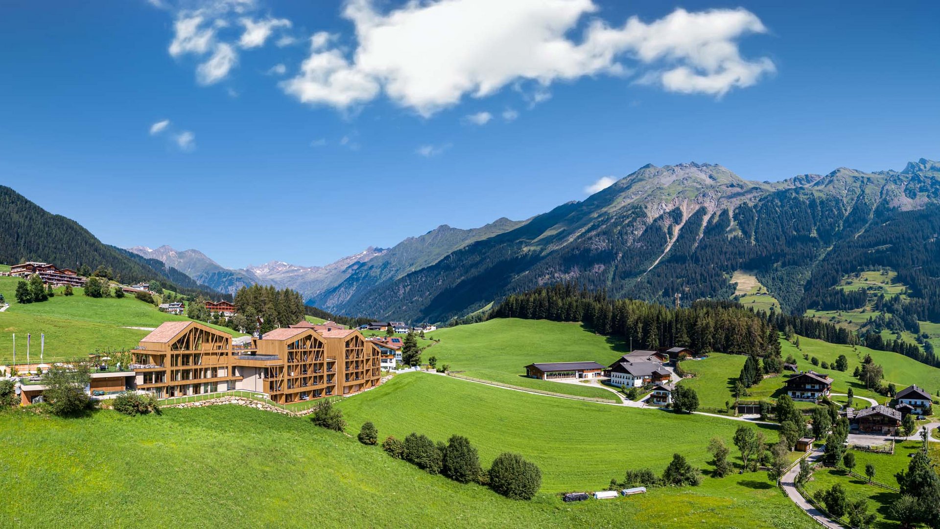 Der Erlebnisort Gassenhof Berglandschaft mit grünem Tal und Häusern unter blauem Himmel
