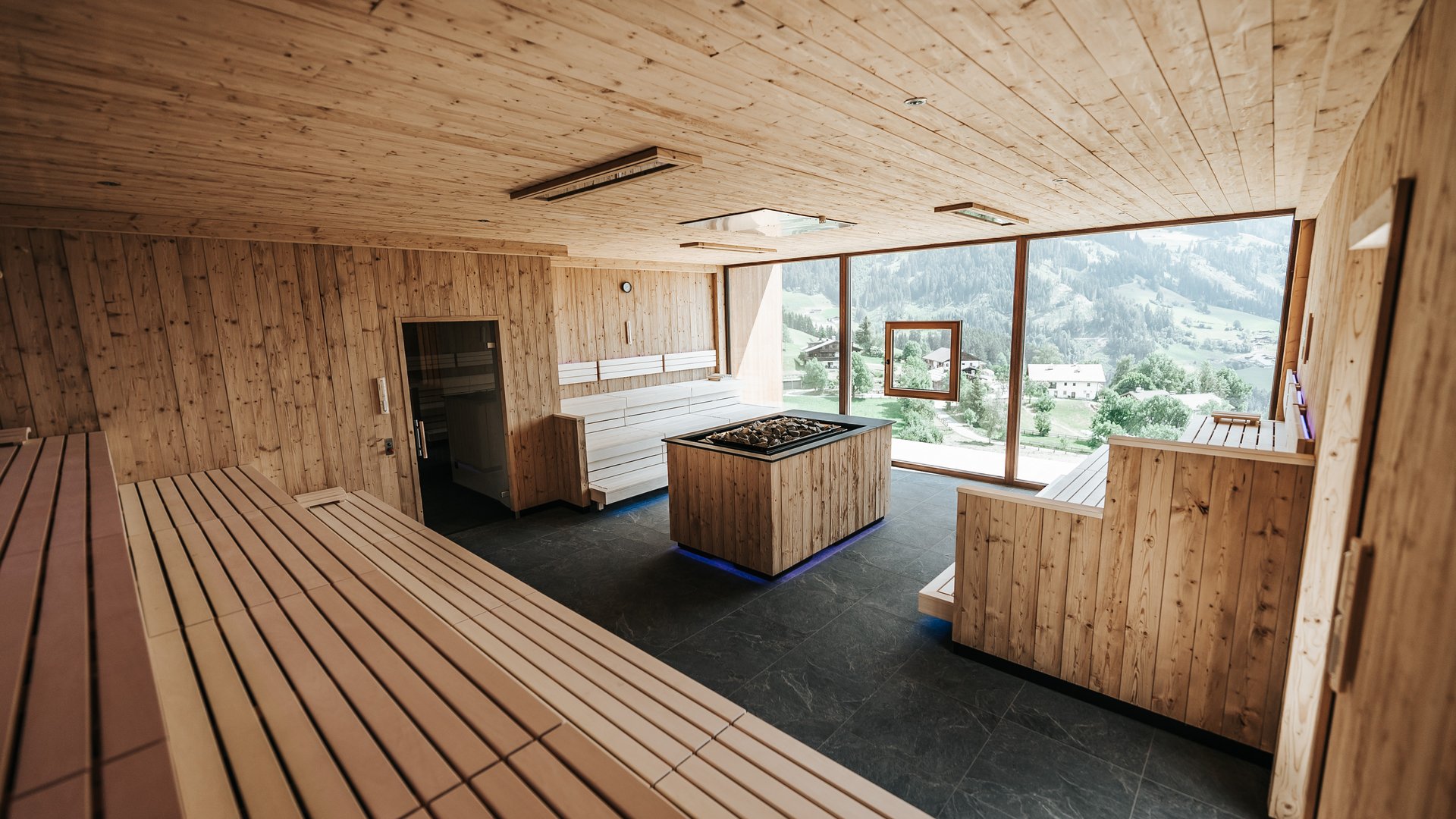Our sauna realm Interior of a wooden sauna with large windows and mountain view