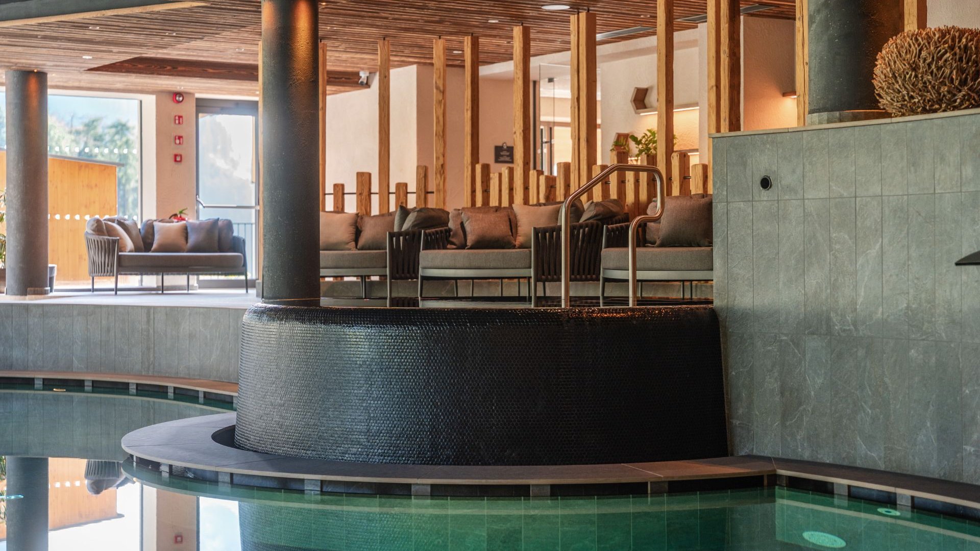 Day Spa Innenpool mit Sitzbereich, Säulen und Holzdecke in einem Wellnessbereich