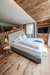 Die Bildergalerie Modernes Hotelzimmer mit Holzwänden, großem Bett und Flachbildfernseher