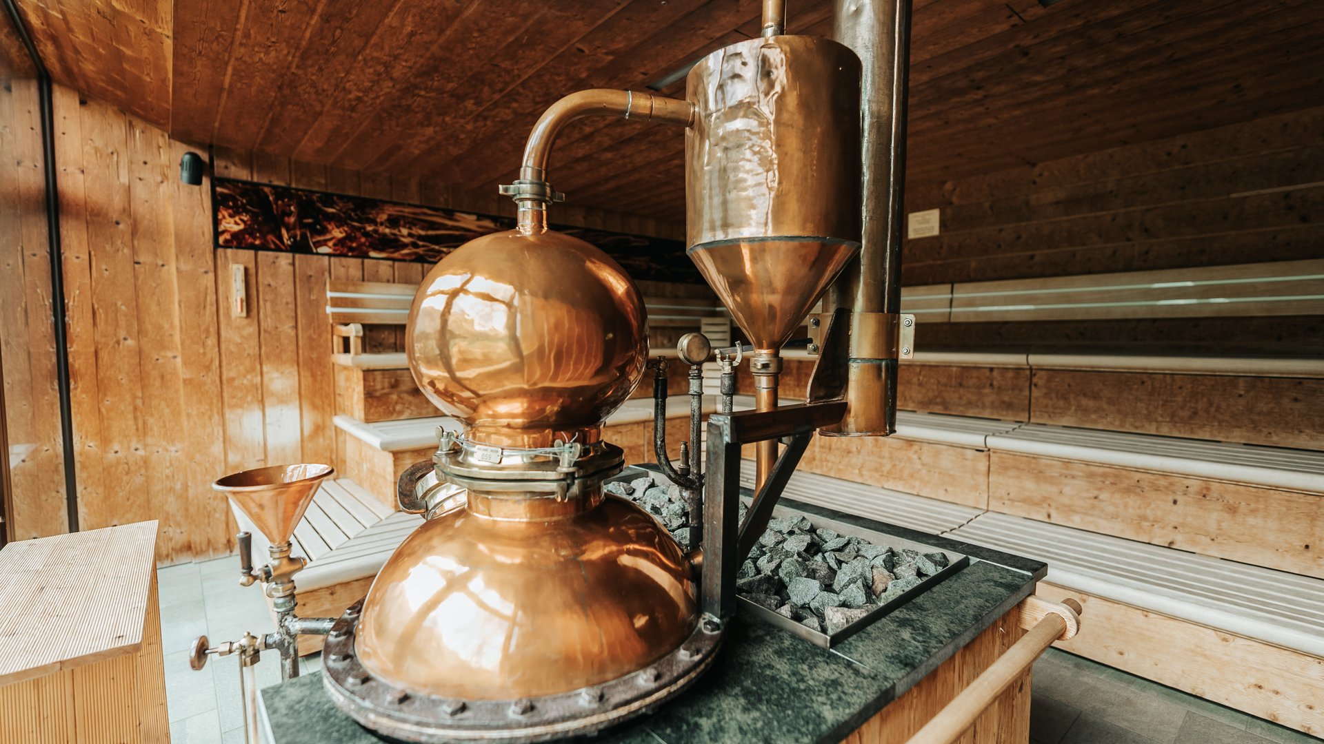 Our sauna realm Copper distillation apparatus inside a wooden sauna room