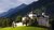 Historisches Schloss vor bewaldeten Bergen und grüner Wiese bei Tageslicht