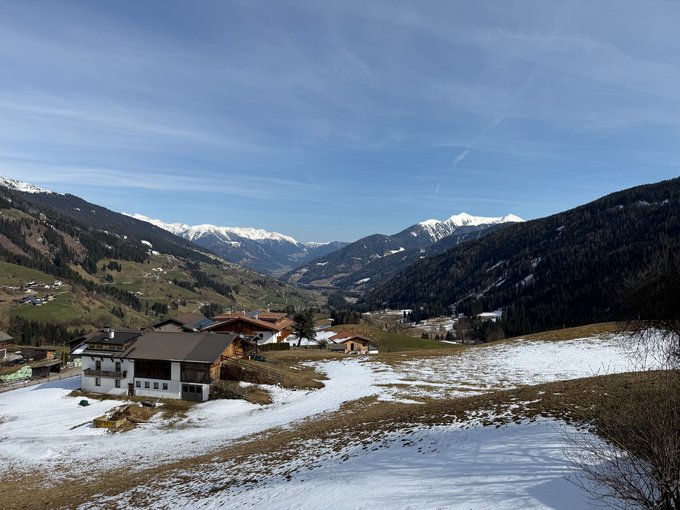 Neu ab Sommer 2026 Berge und Häuser mit schneebedeckten Feldern unter blauem Himmel im Tal