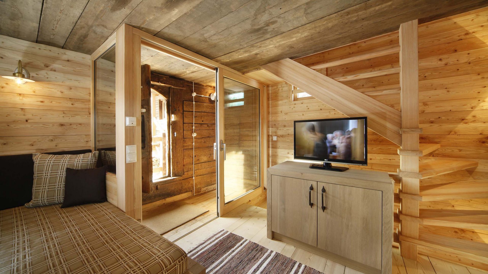 The historical Chalet Gratznhäusl Cozy wooden interior with sofa, TV, and staircase in an alpine cabin