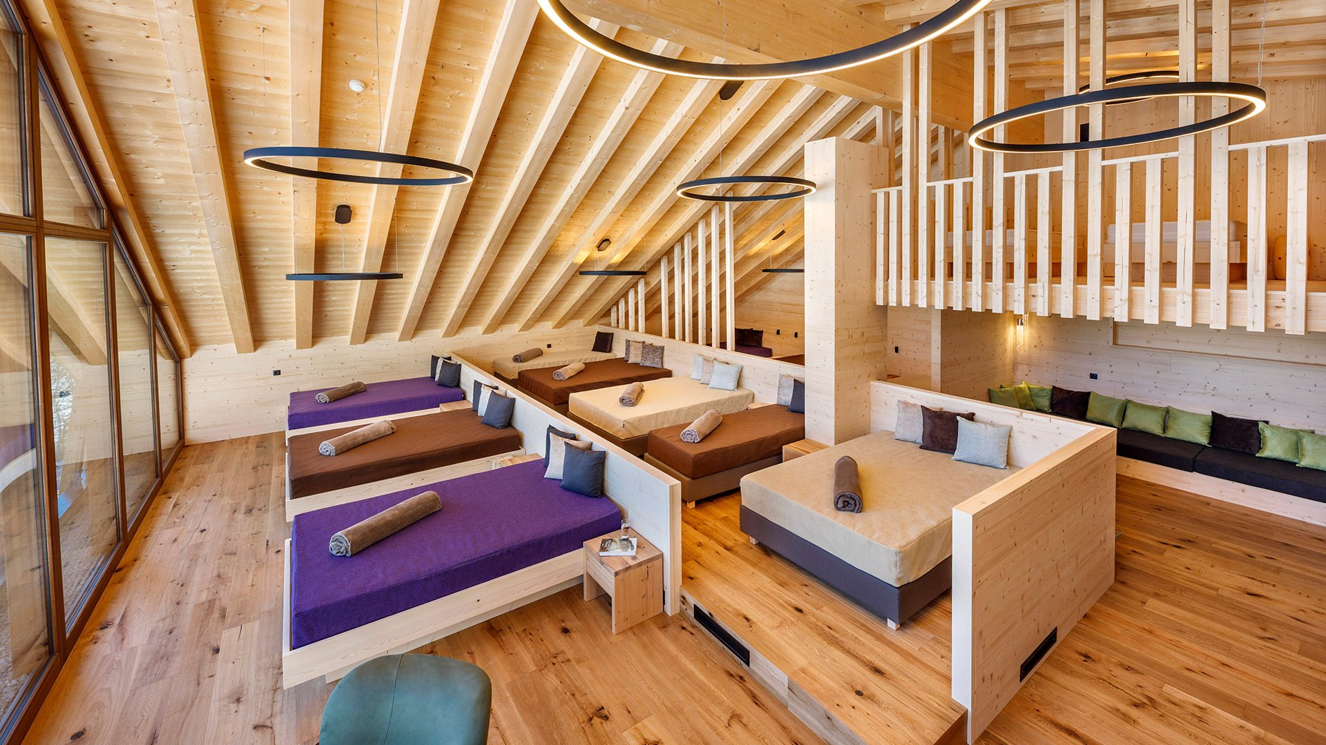 Hotel a Racines con centro benessere Ampia sala relax con lettini e arredi in legno in una spa moderna