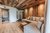 Die Bildergalerie Gemütliches Wohnzimmer mit Holzwänden, Sofa und Blick ins Badezimmer