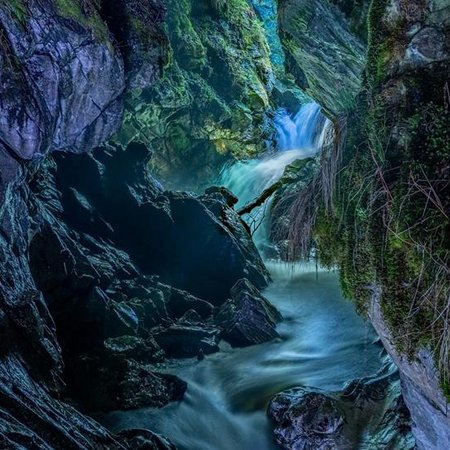 Neuigkeiten Fluss fließt durch eine felsige Schlucht mit moosbedeckten Wänden