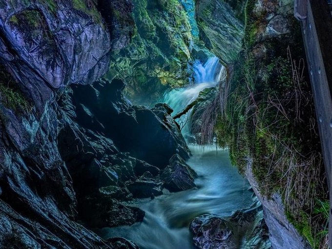 Il potere dell'acqua nelle cascate di Stanghe Fiume che scorre attraverso una gola rocciosa con pareti coperte di muschio