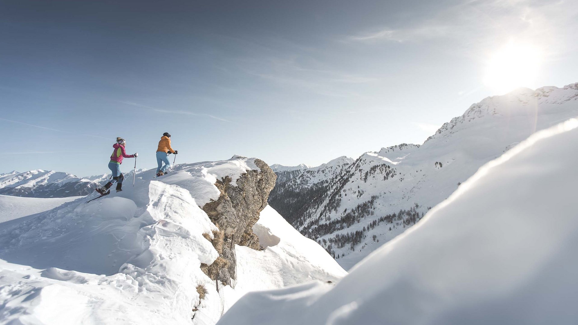 Der Erlebnisort Gassenhof Zwei Personen wandern im Schnee auf einem Berg bei Sonnenschein